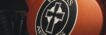 Artistic close-up of a Veritas Aequitas emblem on a motorcycle, featuring a cross design.
